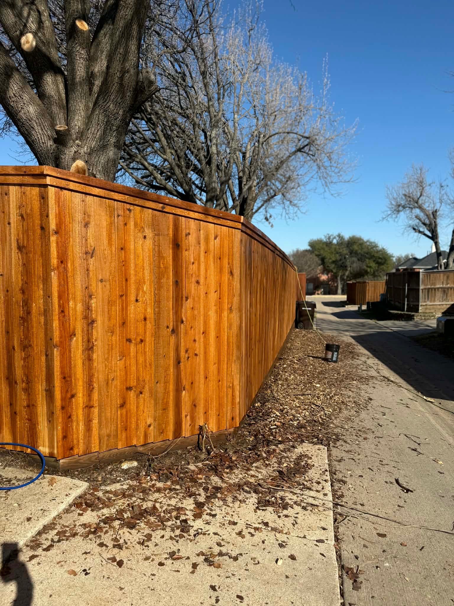 Long stained wood privacy fence along alley